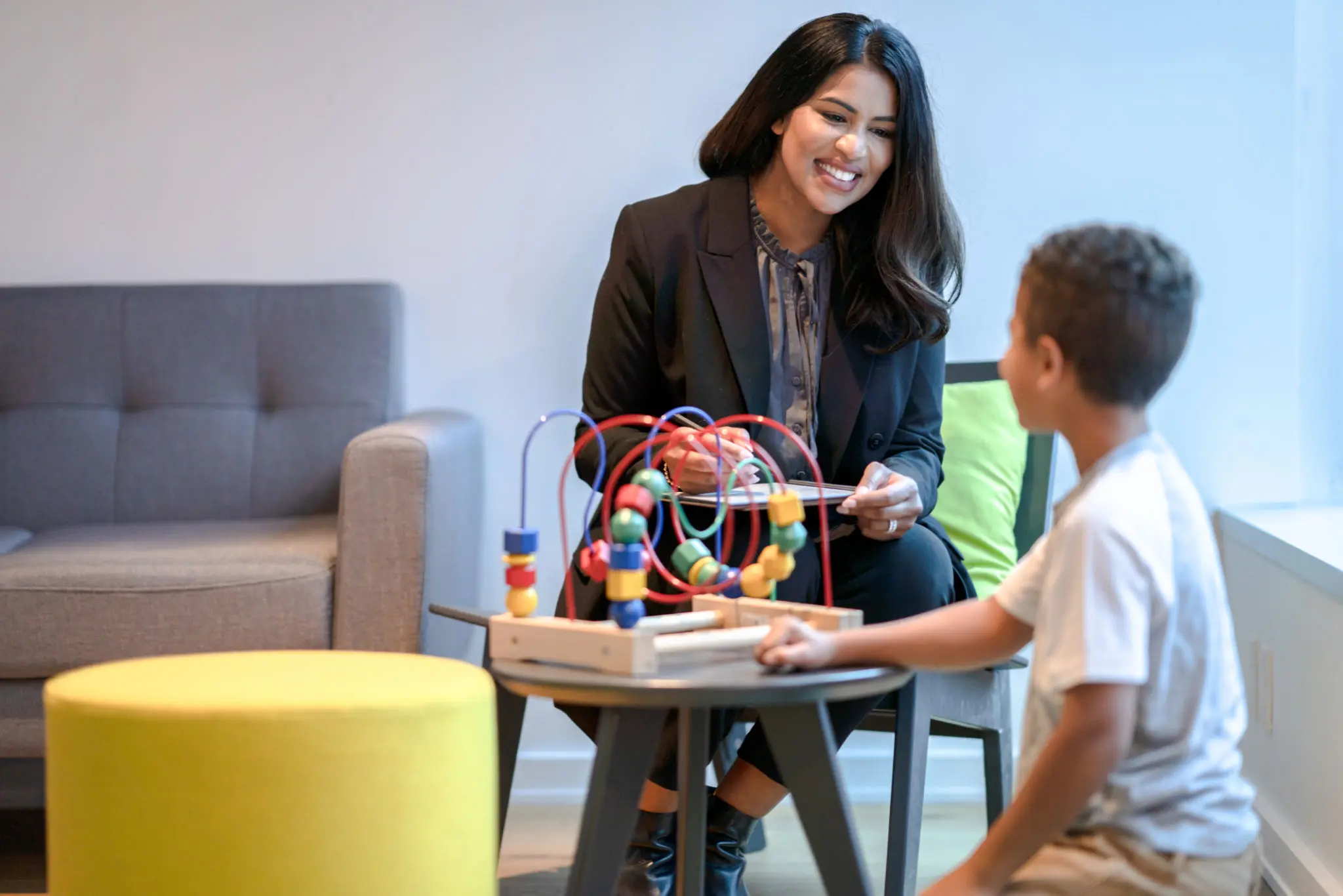 Woman and child playing with educational toy.